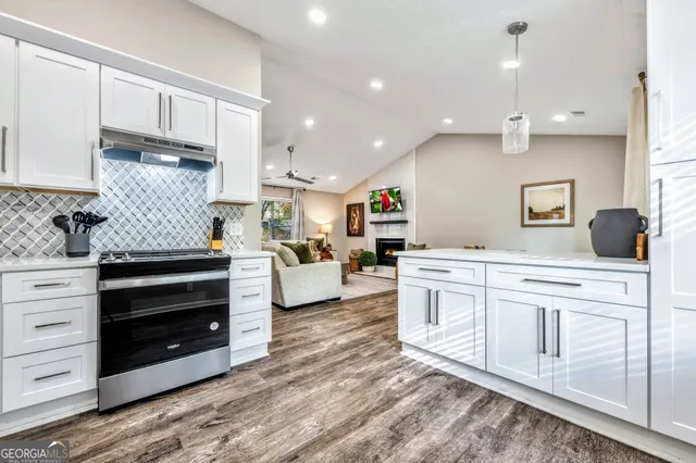 a kitchen with kitchen island granite countertop a stove and a sink