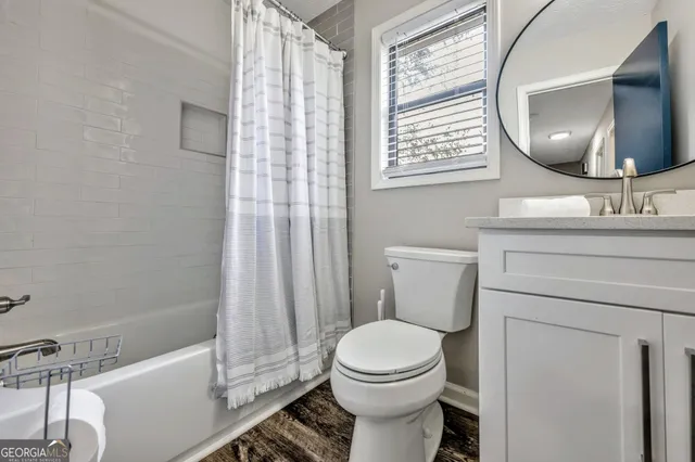 a bed sitting in a bedroom next to a window and dresser