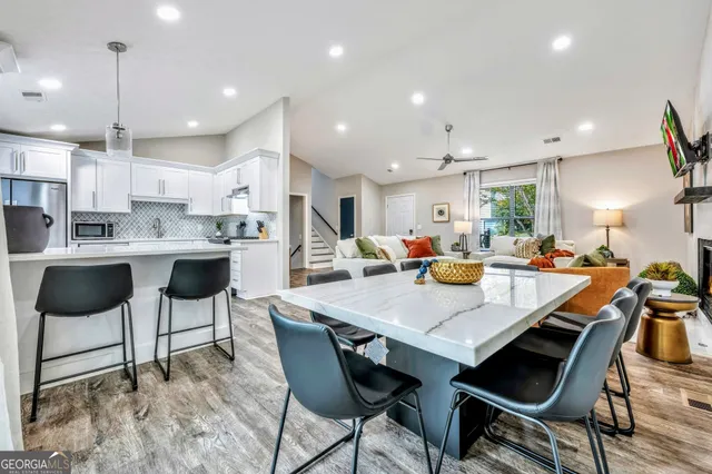 a kitchen with a dining table chairs and refrigerator