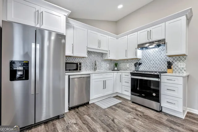a kitchen with stainless steel appliances a refrigerator sink and cabinets