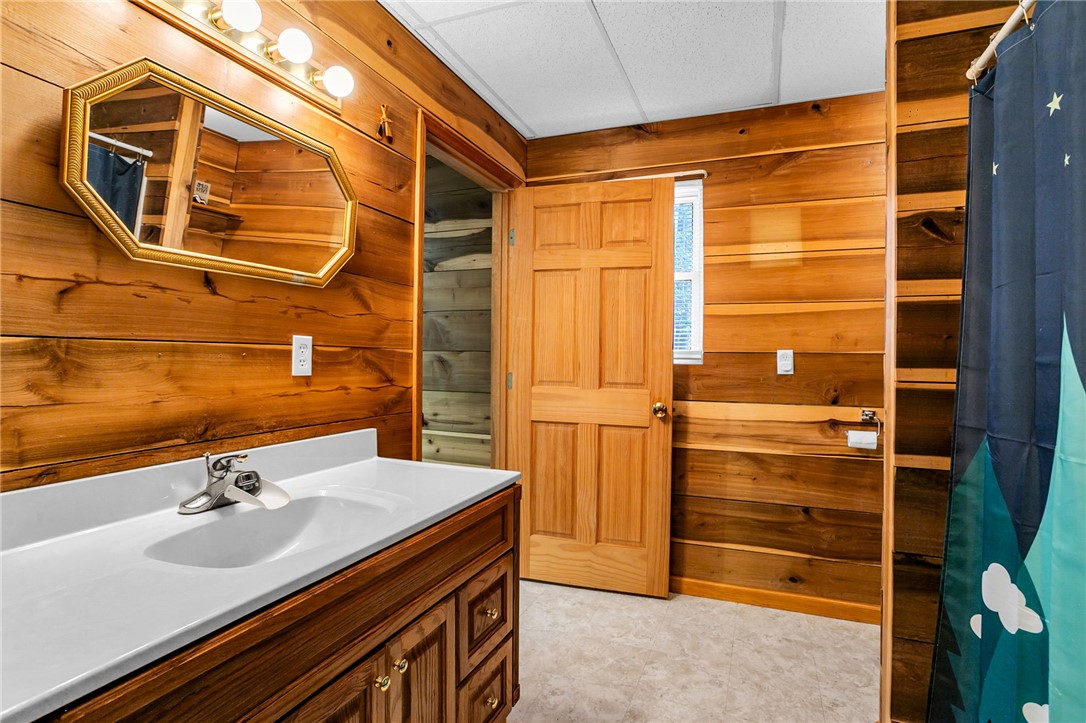 130 Greenbrier Road Salem, SC 29676 - Photo 36 of 48 This bathroom features wood paneling and a clean, functional vanity with classic fixtures.