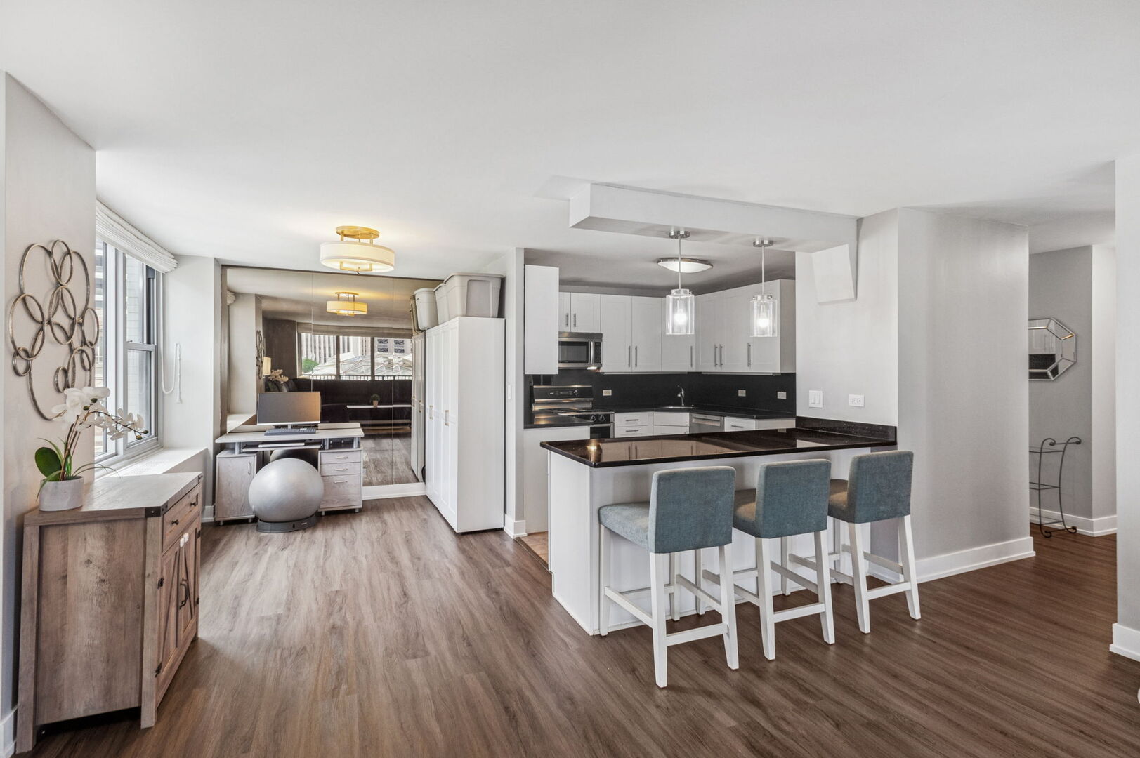 400 East Randolph Street, Unit 930 Chicago, IL 60601 - Photo 4 of 34 a kitchen with stainless steel appliances kitchen island wooden floors and center island