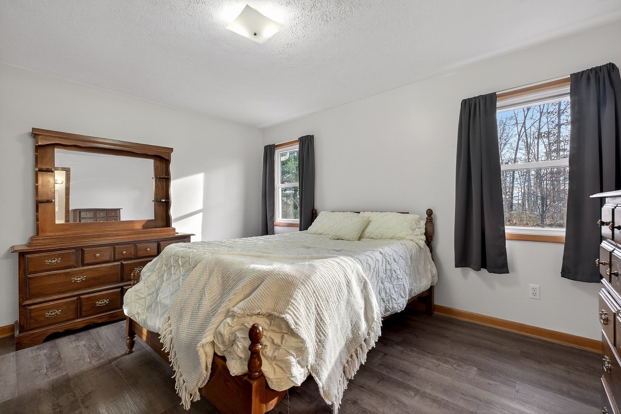 8607 Bockman Way Sparta, TN 38583 - Photo 15 of 34 a bedroom with a bed and a large mirror on dresser with wooden floor