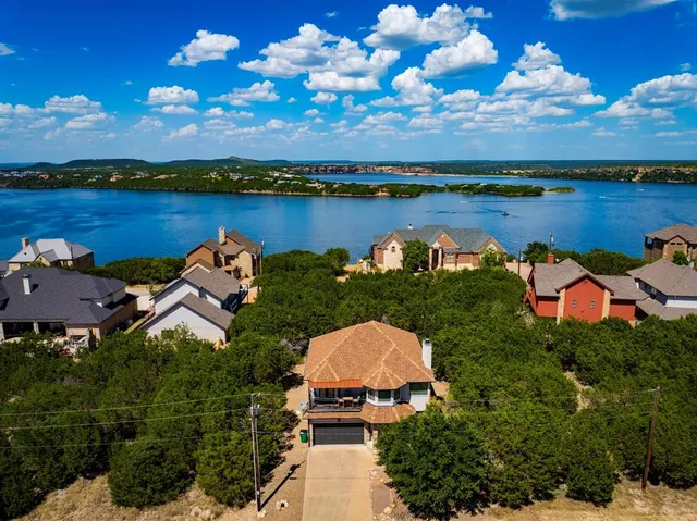 an aerial view of a house with outdoor space and lake view in back