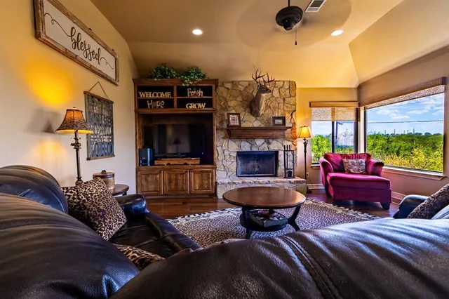 a living room with furniture a flat screen tv and a fireplace