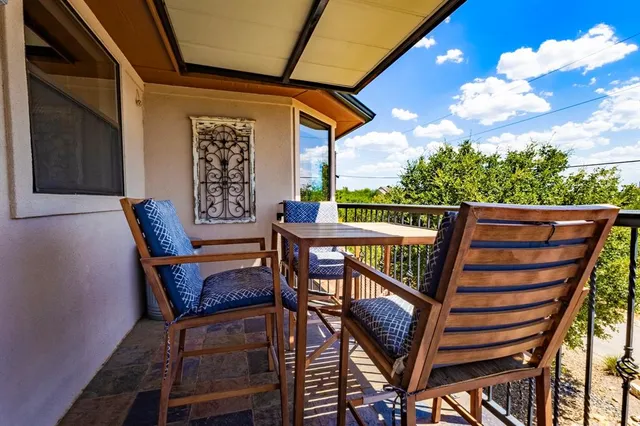 a view of a chairs and table in the balcony