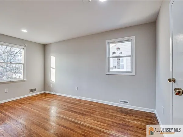 a view of empty room with wooden floor