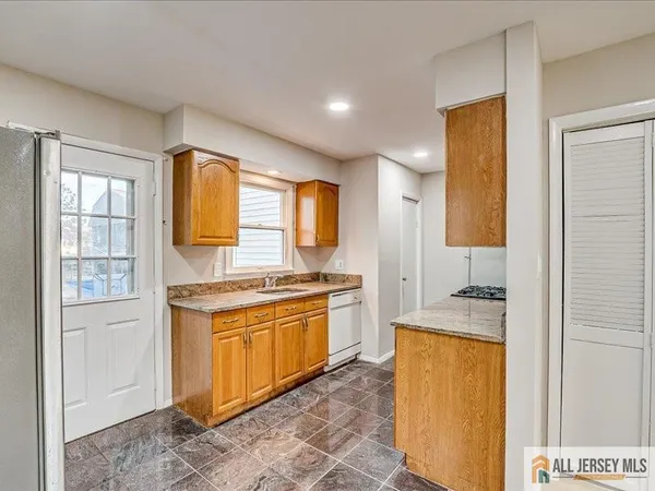 a large kitchen with stainless steel appliances granite countertop a stove and a sink