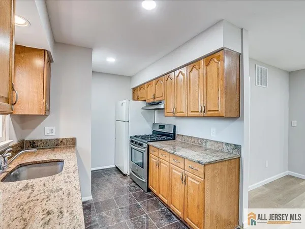 a kitchen with stainless steel appliances granite countertop a sink stove and cabinets