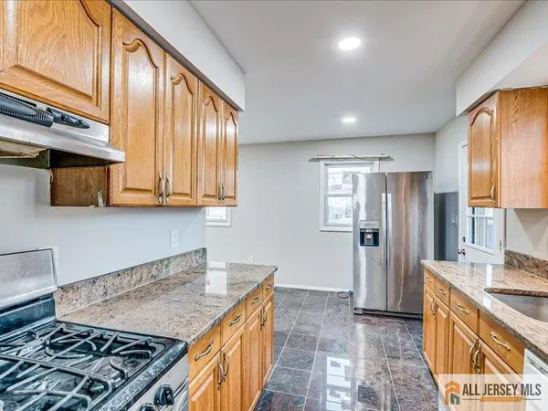 a kitchen with stainless steel appliances granite countertop a sink stove and refrigerator