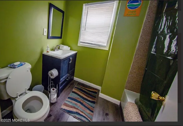 a bathroom with a toilet mirror and vanity