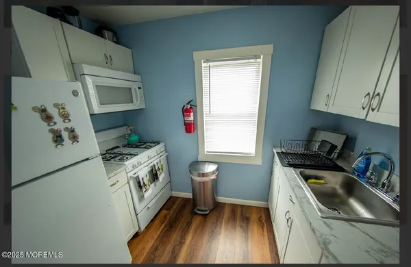 a kitchen with granite countertop a sink a stove and refrigerator