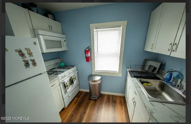 a kitchen with granite countertop a sink a stove and refrigerator