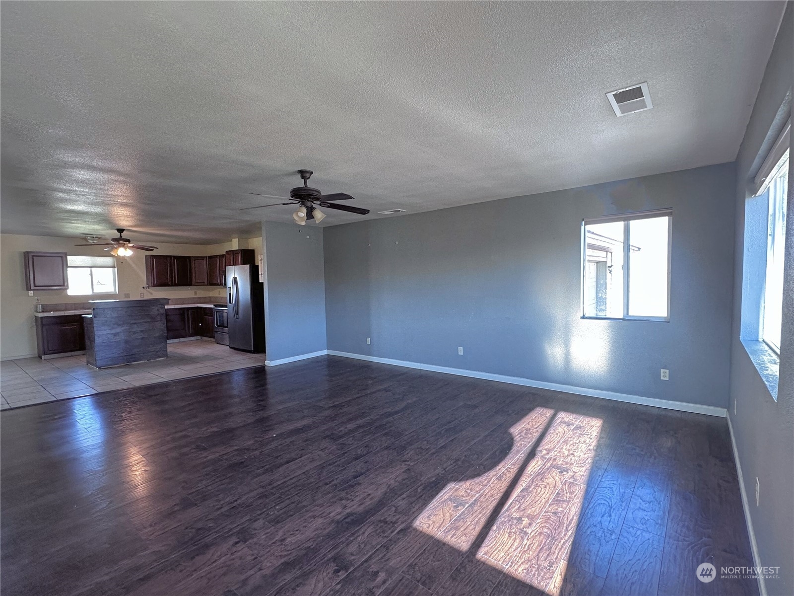 19 Jess Botello Place Riverside, WA 98849 - Photo 5 of 30 an empty room with wooden floor fireplace and windows