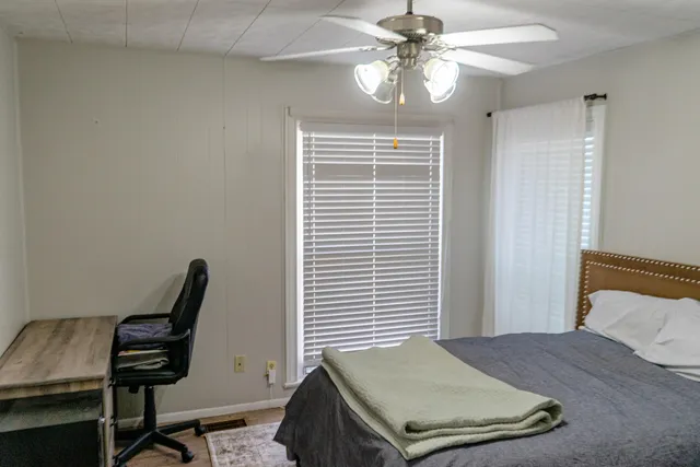 an empty room with wooden floor closet and windows