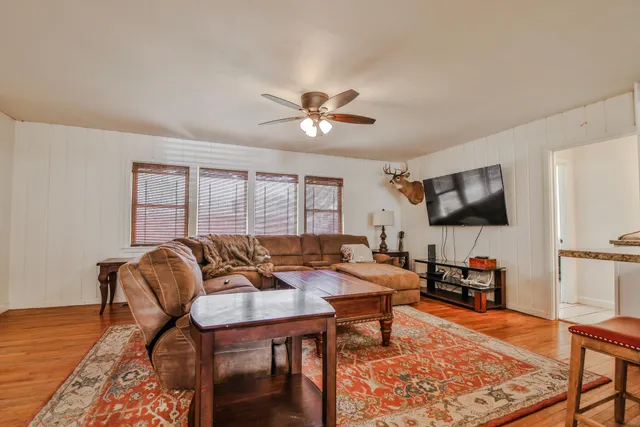 a living room with furniture a flat screen tv and a window