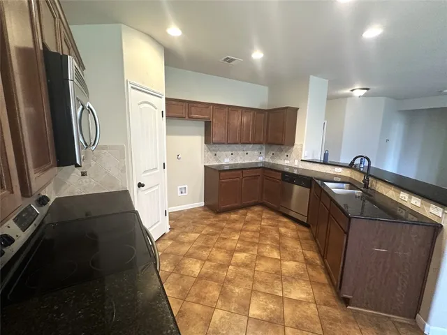a kitchen with stainless steel appliances a sink stove and cabinets