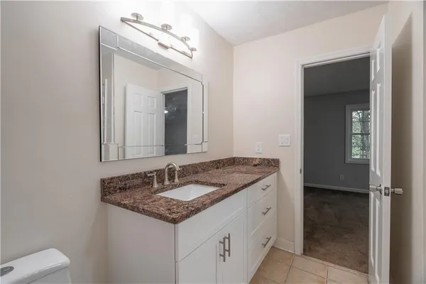 a bathroom with a granite countertop sink and a mirror