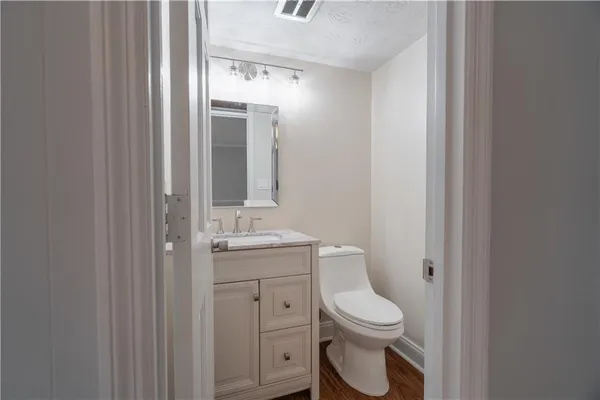 a bathroom with a toilet a sink and mirror