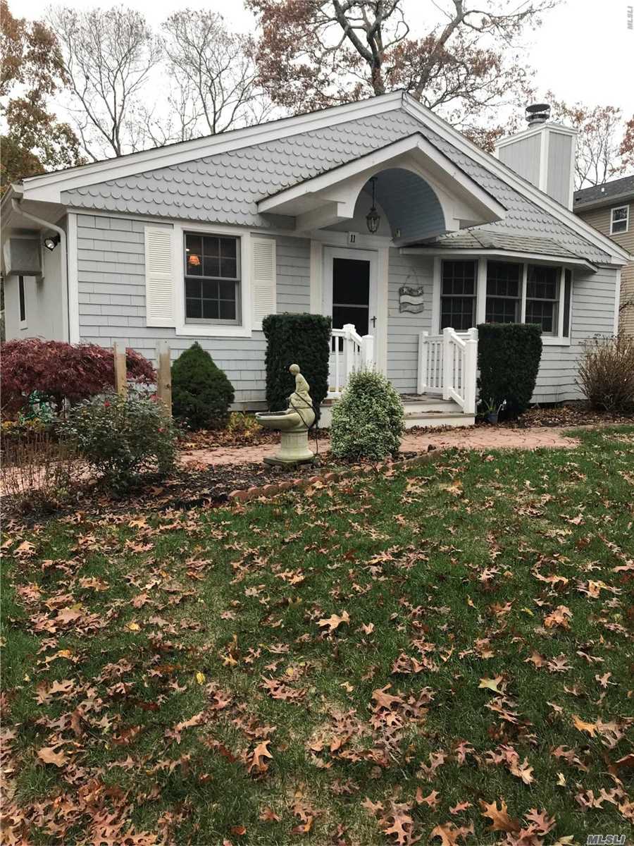 11 Shore Road Hampton Bays, NY 11946 - Photo 1 of 1 a front view of house with yard and trees around