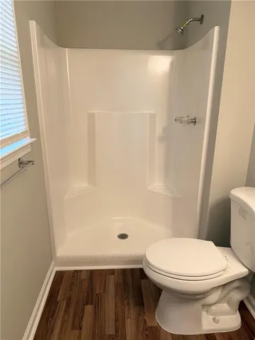 a bathroom with a toilet and a shower