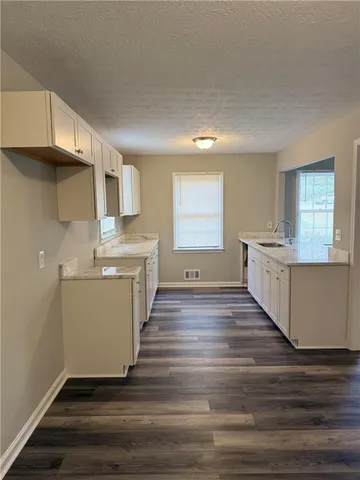 a view of a kitchen with a sink cabinets and wooden floor
