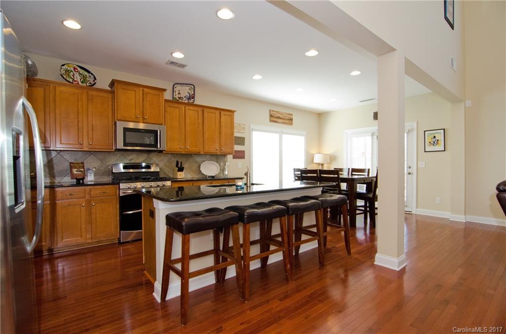 16827 Rudence Court Charlotte, NC 28278 - Photo 8 of 24 a kitchen with stainless steel appliances wooden floors and wooden cabinets