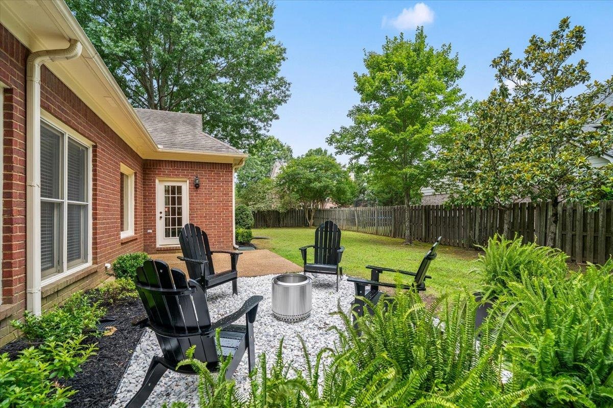 1876 Liles Lane Collierville, TN 38017 - Photo 35 of 36 Expansive backyard featuring a manicured lawn, established trees, and a wooden privacy fence