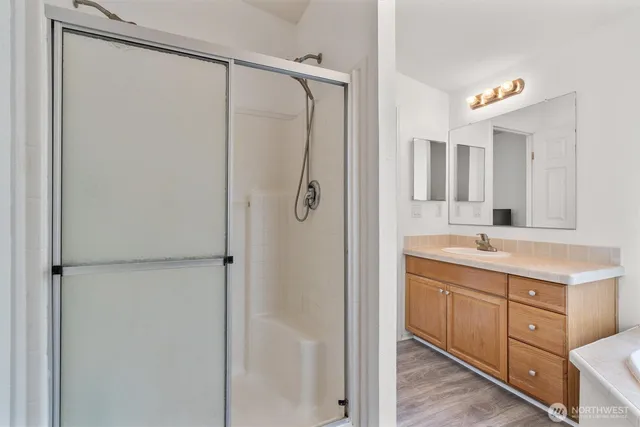 a bathroom with a double vanity sink mirror and shower