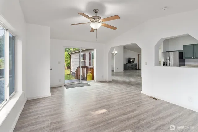 a view of a livingroom with a furniture wooden floor and a ceiling fan