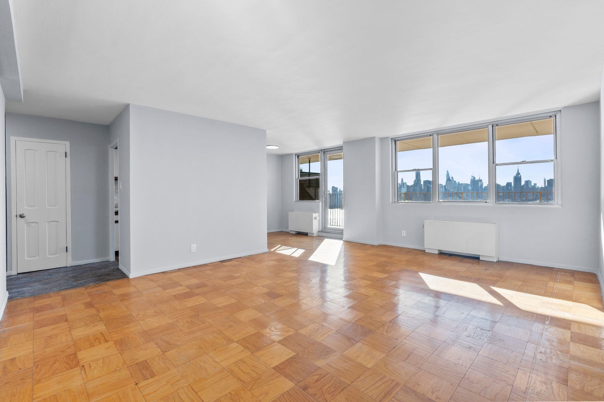 6040 Boulevard East, Unit 14F West New York, NJ 07093 - Photo 15 of 34 a view of empty room with wooden floor and fireplace
