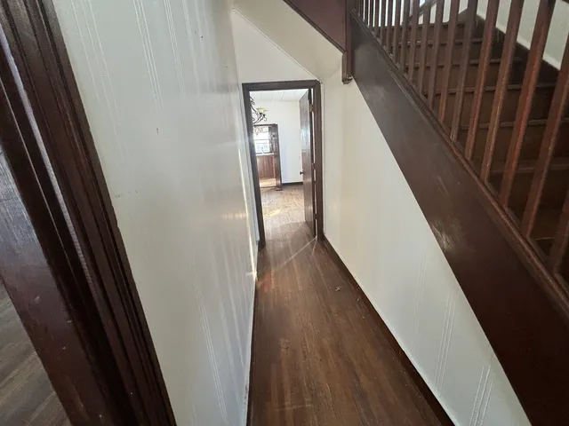 a view of a hallway with wooden floor and staircase