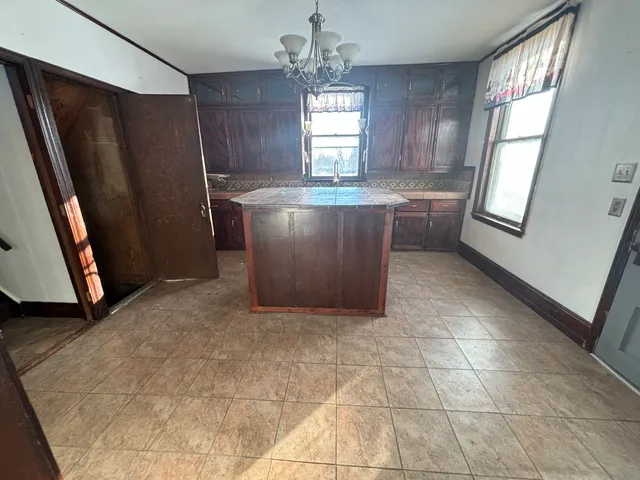 a view of kitchen with granite countertop window and refrigerator
