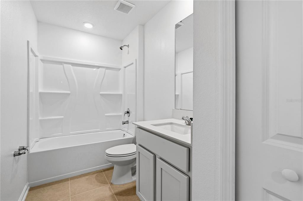 3644 Rolling Rdg Bend Davenport, FL 33837 - Photo 20 of 31 a bathroom with a granite countertop sink a toilet and shower