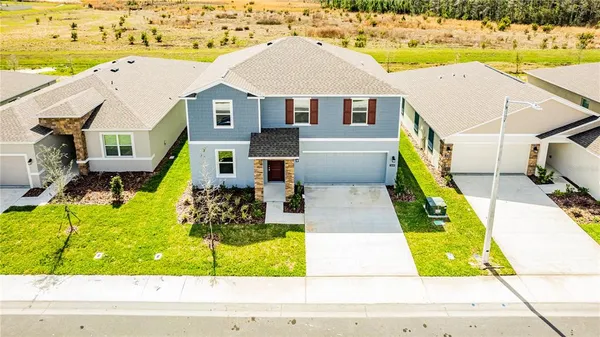 a aerial view of a house with swimming pool and next to a yard