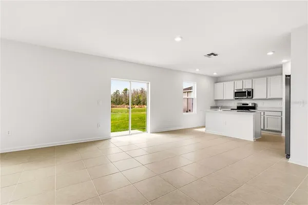 a view of kitchen with granite countertop a stove top oven a sink and a window