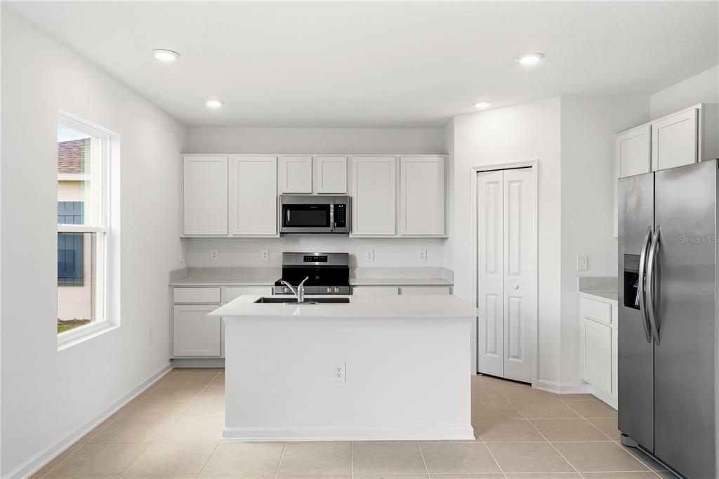 3644 Rolling Rdg Bend Davenport, FL 33837 - Photo 6 of 31 a kitchen with a refrigerator stove and microwave