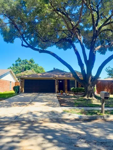 a view of house with yard outdoor seating and trees in the background