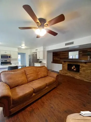 a living room with furniture and a wooden floor
