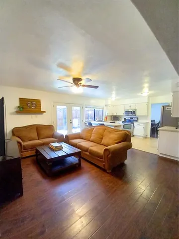 a living room with furniture and a wooden floor