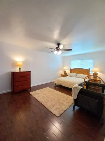 a bedroom with a bed and a ceiling fan
