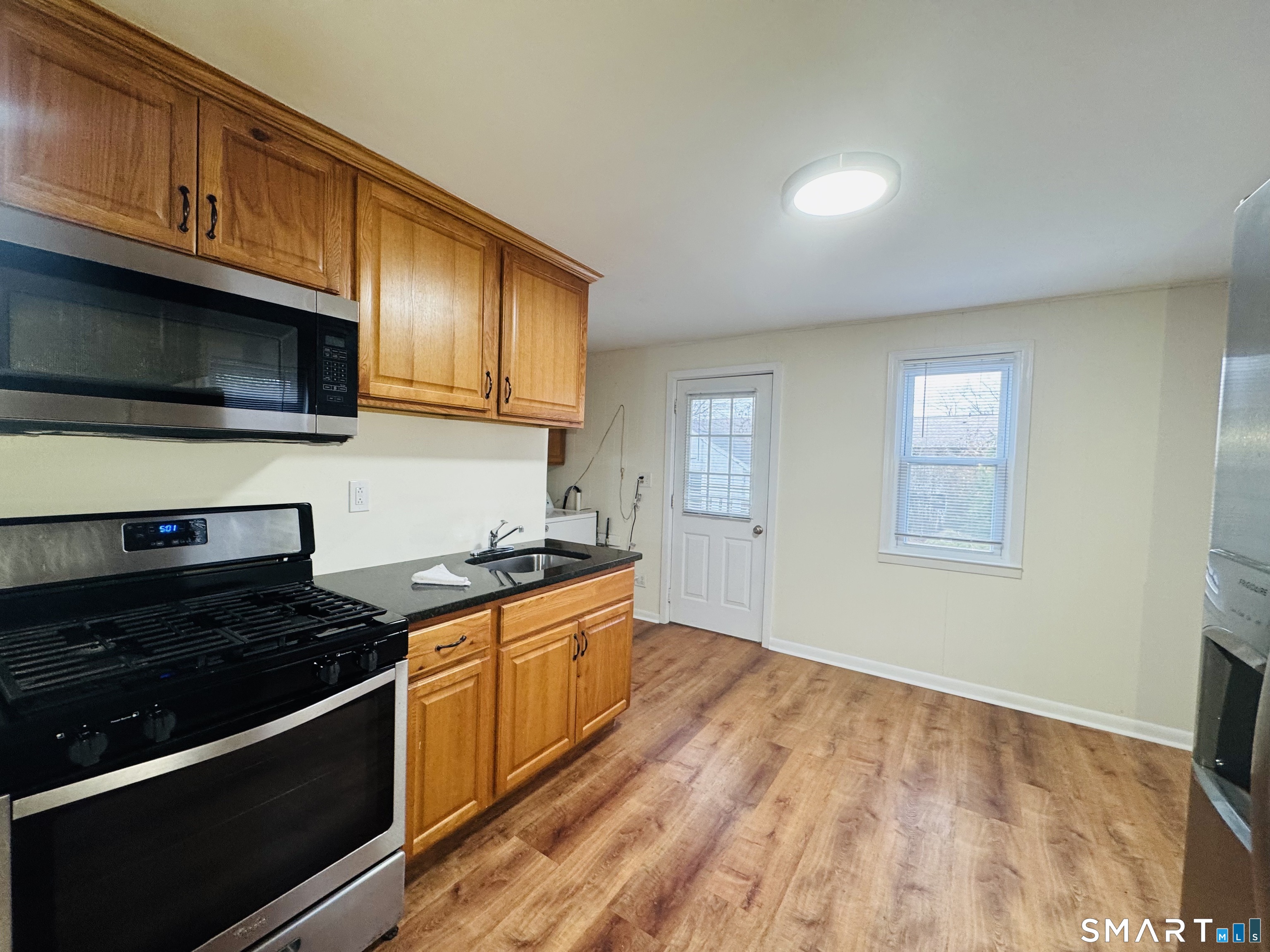 11 Trefoil Court Fairfield, CT 06825 - Photo 2 of 13 a kitchen with granite countertop wooden cabinets stainless steel appliances and a sink