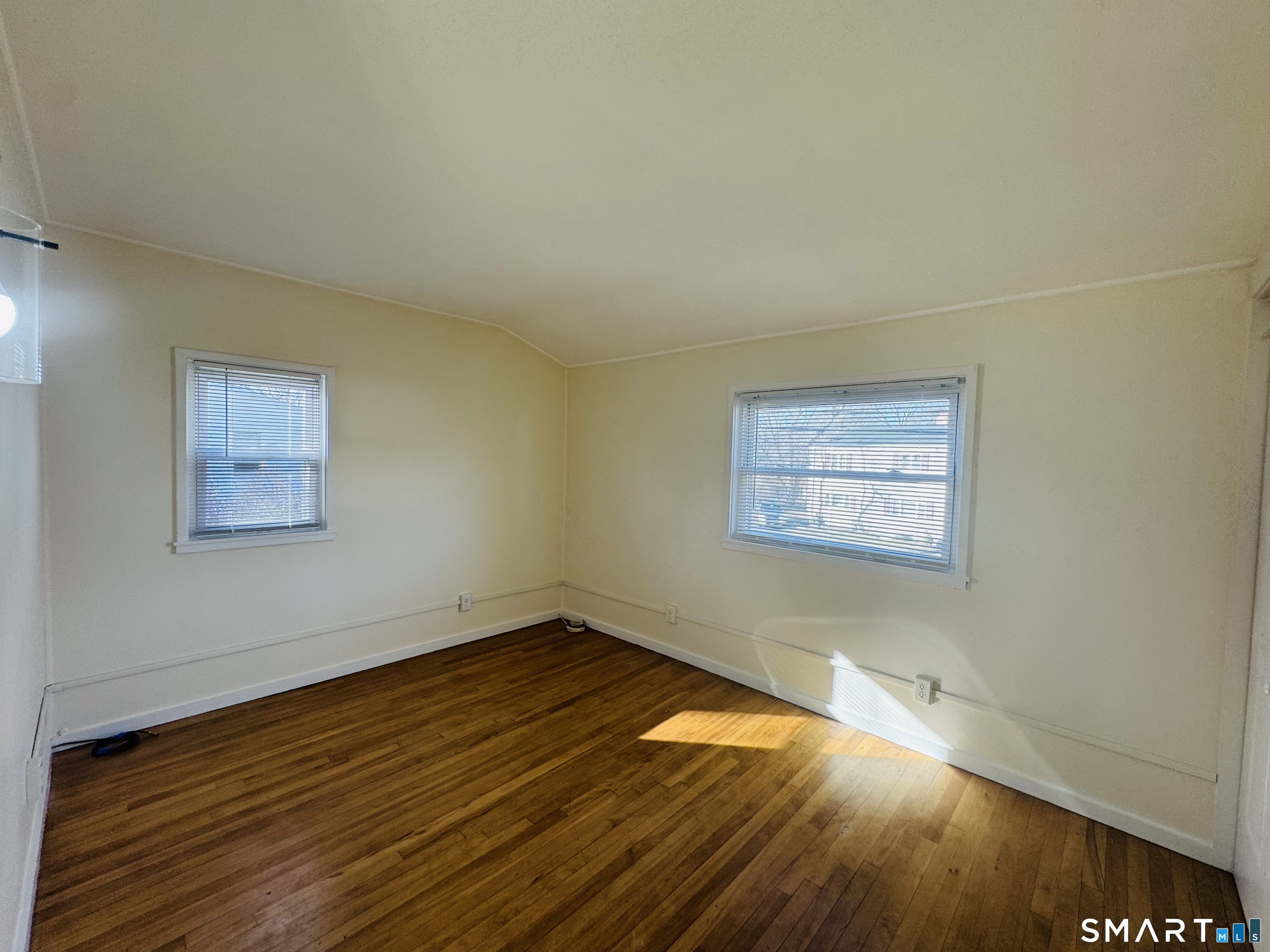11 Trefoil Court Fairfield, CT 06825 - Photo 6 of 13 an empty room with wooden floor and windows