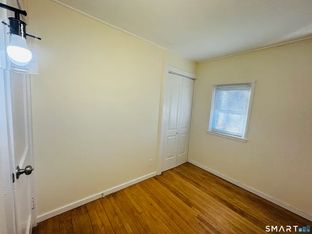 a view of a room with wooden floor and a window