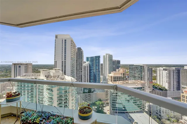 a view of a white house with large windows and a fireplace