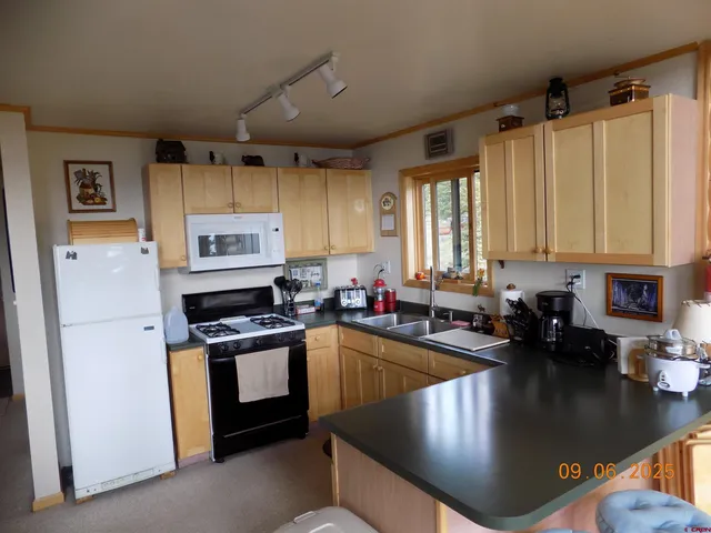a kitchen with stainless steel appliances granite countertop a sink a stove and a refrigerator