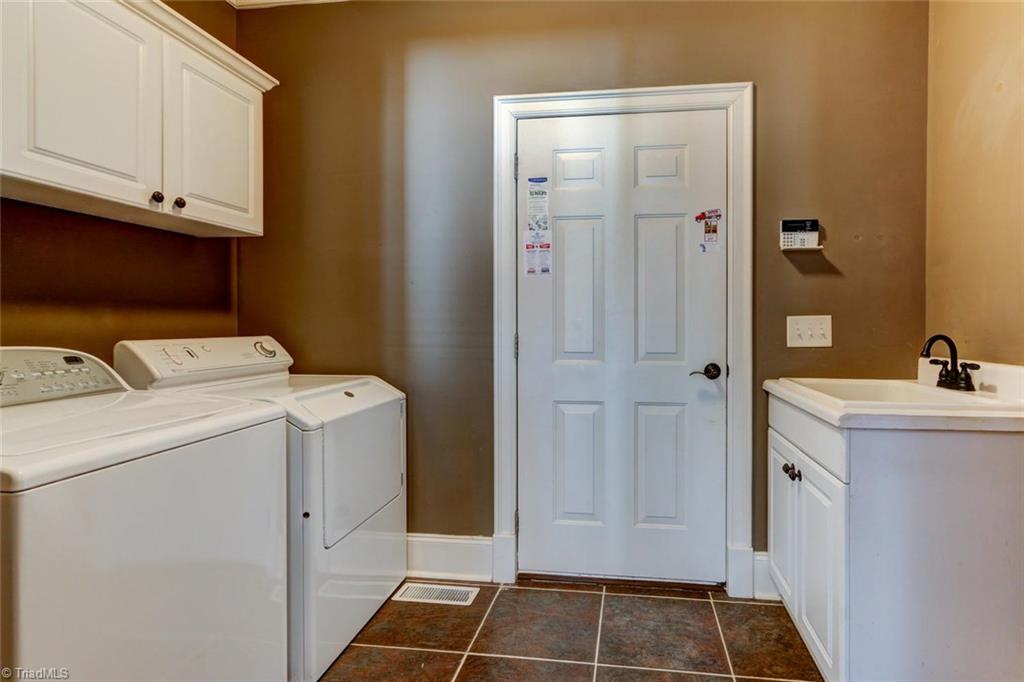 8525 Rosedale Drive Oak Ridge, NC 27310 - Photo 12 of 28 The laundry features cabinetry, tile flooring and the sought after wash out sink! Perfect "drop zone".