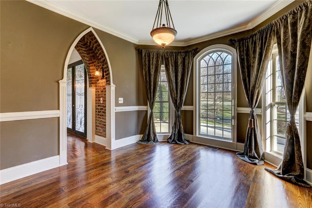 8525 Rosedale Drive Oak Ridge, NC 27310 - Photo 3 of 28 The exterior tower roof elaborations render interesting interior spaces such as this quiet front room. Floor-to-ceiling front windows add great light. Gleaming wide plank hardwood flooring. A great place for a grand piano, library, sitting room or office.