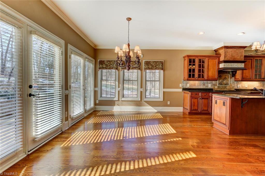 8525 Rosedale Drive Oak Ridge, NC 27310 - Photo 6 of 28 The breakfast area is oversized with a wall of windows overlooking the spectacular back yard. Hardwood flooring is carried throughout the main level except in the master bedroom and bath.