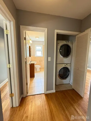a view of a hallway with wooden floor and cabinets